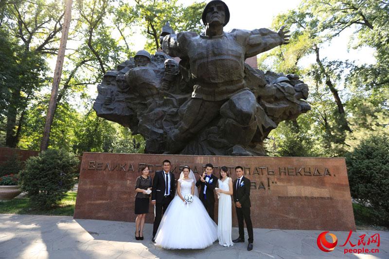 一对新婚夫妇和他们的亲友在潘菲洛夫-28勇士纪念公园合影留念 人民网记者 赵亚辉 摄