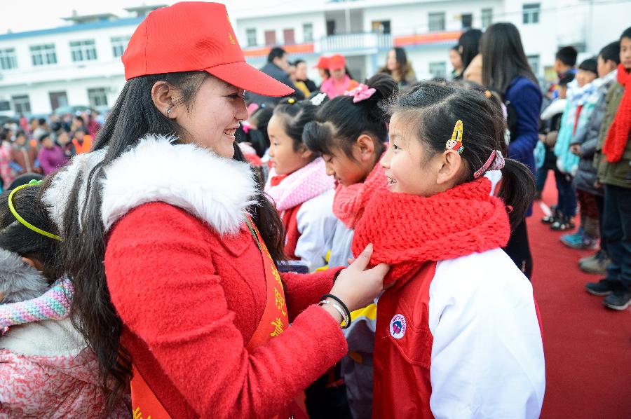 12月29日,大学生志愿者(左)为一名留守儿童戴上围巾。当日,安徽城市管理职业学院的大学生志愿者来到合肥市新站区于湾村,将自己亲手编织的围巾送给村里留守儿童及家庭困难儿童,给孩子们带去冬日的温暖。新华社记者 张端 摄