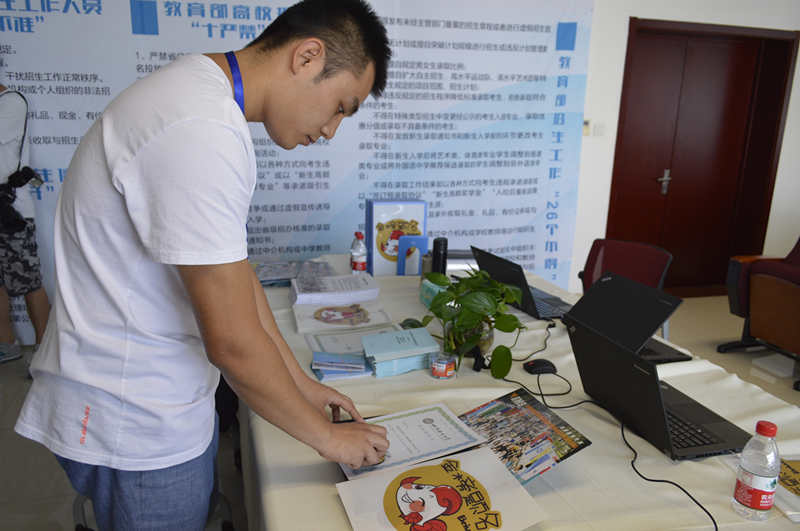 北京语言大学招生办老师为打印好的录取通知书盖公章。人民网 刘然 摄