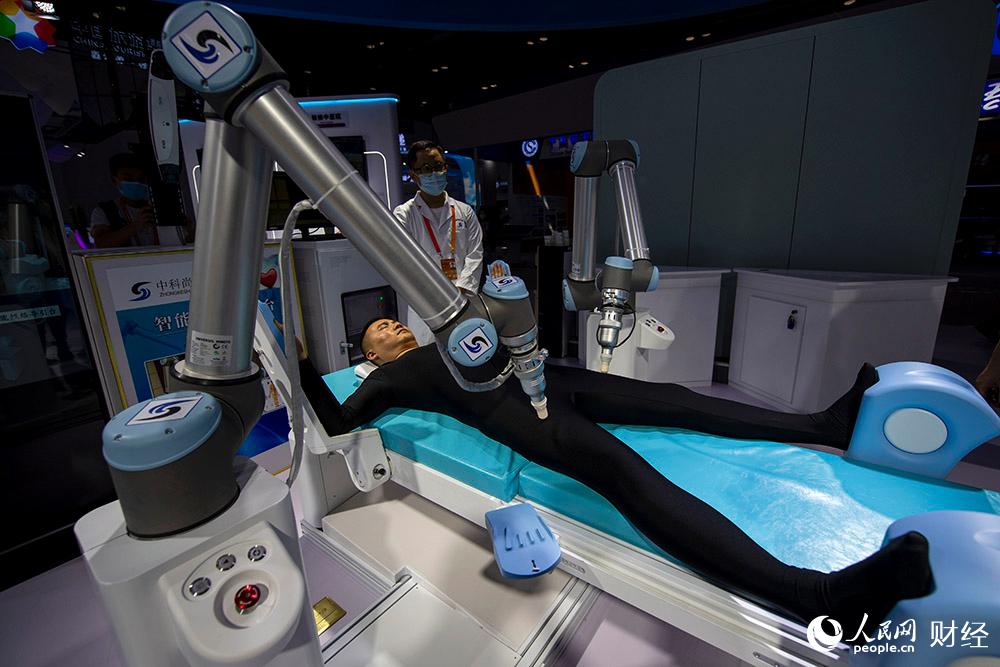 9月4日，在2020服貿會綜合展區，參觀者正在體驗中醫智能經絡導引機器人。（人民網記者 翁奇羽 攝）