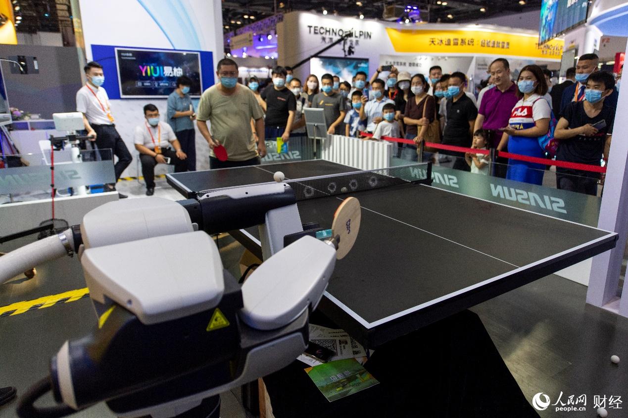 參觀者與乒乓發球機器人同場競技。（人民網記者翁奇羽攝）