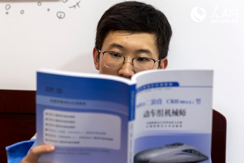 工作之余，王澤鋒在宿舍看書，學習業務知識，為節后的技能比賽做准備。人民網記者 翁奇羽攝