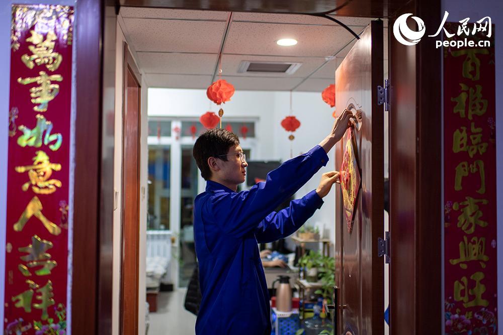 2月10日大年廿九，趁著中班開工前，王澤鋒正在粘貼福字，為宿舍增添一下節日氣氛。人民網記者 翁奇羽攝