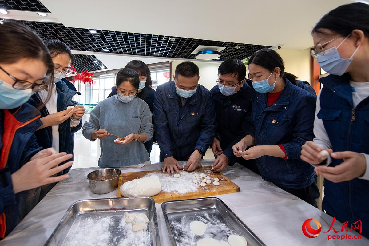 忙完一天工作，張琳回到單位食堂與留守北京的同事一起包起餃子。人民網記者 翁奇羽攝