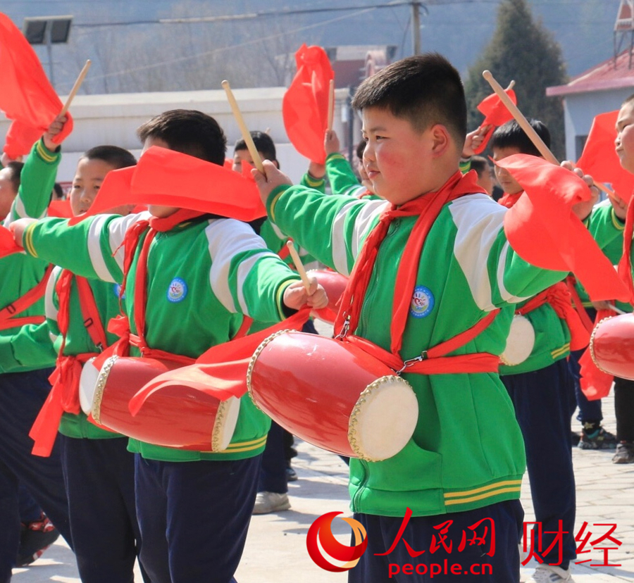 平坊滿族鄉中心小學學生在操場上，伴著春日暖陽練習腰鼓。人民網 黃盛攝