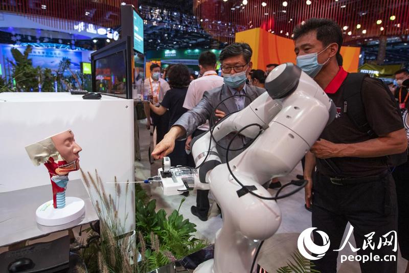 在服務貿易發展成就展上，觀眾正在參觀自動鼻咽拭子機器人。人民網記者 翁奇羽攝