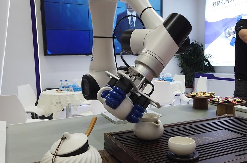 智能手臂机器人正在向观众展示茶艺。人民网记者 王震摄