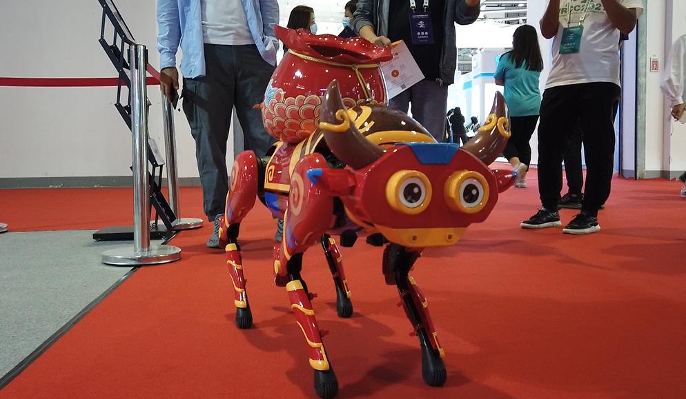 披着福牛外套的“机器狗”正在展示拜年、翻跟头等“才艺”。人民网记者 王震摄