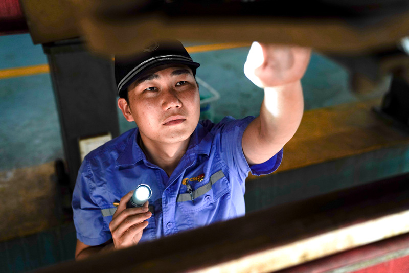 南寧動車組機械師裴德堂在對動車組轉向架進行檢查作業。全國鐵道團委供圖