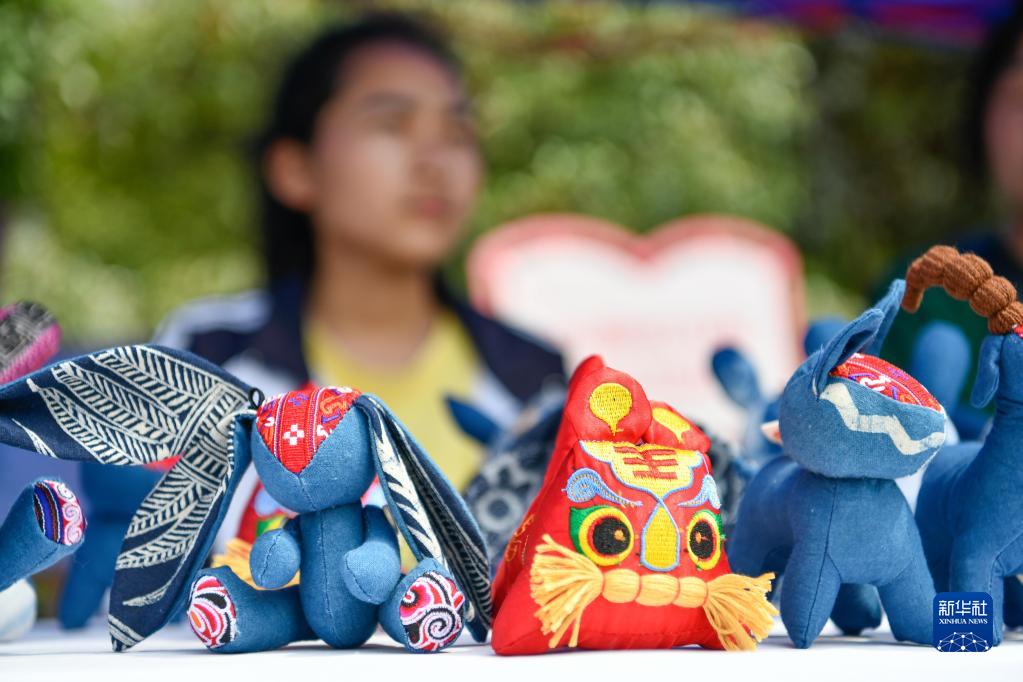6月26日，贵州省龙里县中等职业学校的学生在展示手工布艺作品。