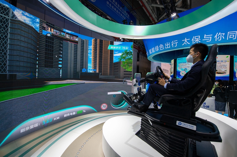 11月6日，在进博会汽车展区的中国太平洋保险展台，参观者正在体验模拟自动驾驶。人民网记者 翁奇羽摄