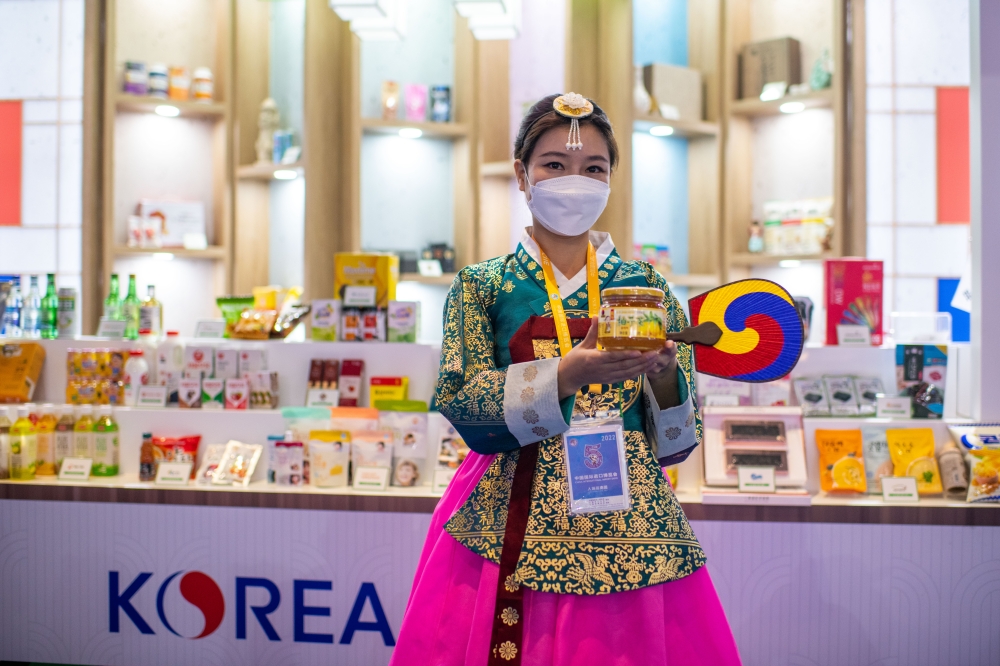 在第五屆進博會食品及農產品展區，身穿韓服的參展商工作人員正在推介韓國食品。人民網記者 翁奇羽攝
