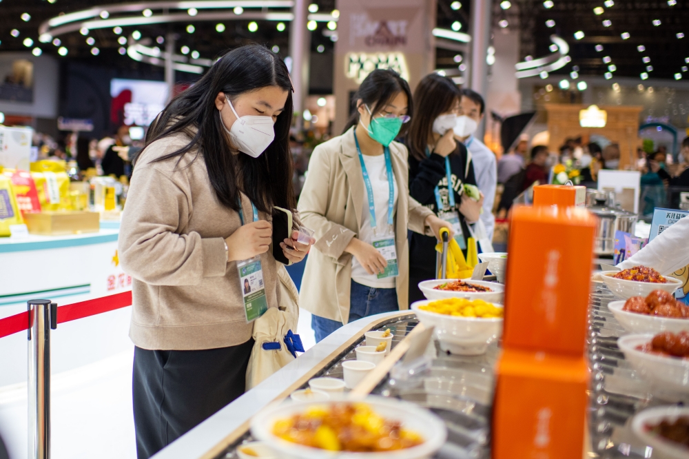 在第五屆進博會食品及農產品展區，參觀者現場試吃。人民網記者 翁奇羽攝