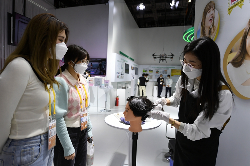 在第五屆進博會消費品展區的花王展台，參展商正在演示如何使用泡沫染發膏染發。人民網記者 翁奇羽攝