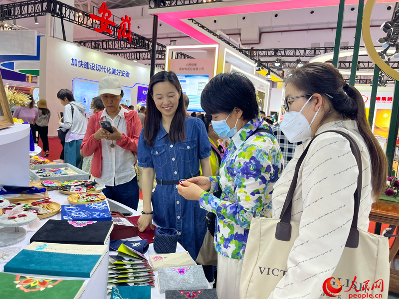 參觀者在消博會雲南展區購買彝族刺繡產品。人民網記者 杜燕飛攝