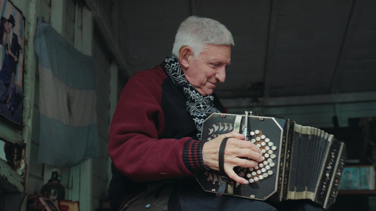 街头艺人诺尔贝托正在弹奏班多钮手风琴。人民网记者张若涵 摄