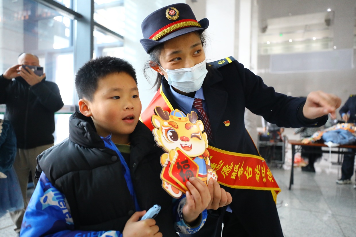 铁路工作人员正在与小旅客互动。春庄钰翔摄