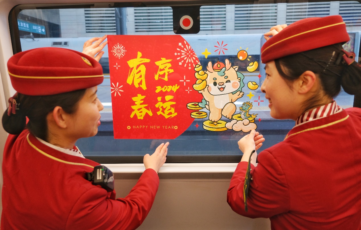 春运首日,乘务员在车厢内贴窗花营造喜庆氛围。杨宝森摄