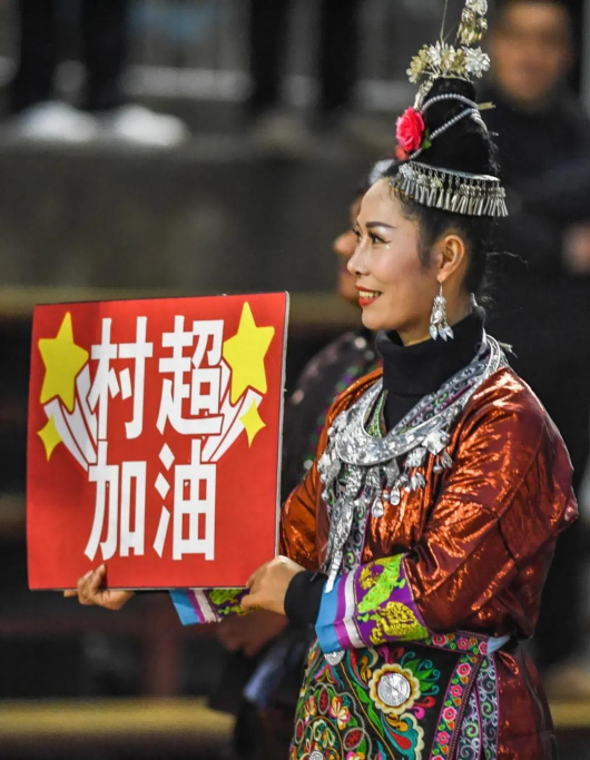 1月7日，一位村民手举“村超加油”的标牌 新华社记者 陶亮 摄 