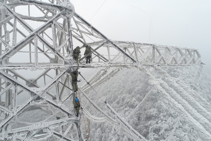 国网湖北送变电公司运维人员清除输电线路地线和光缆上的覆冰。受访者供图