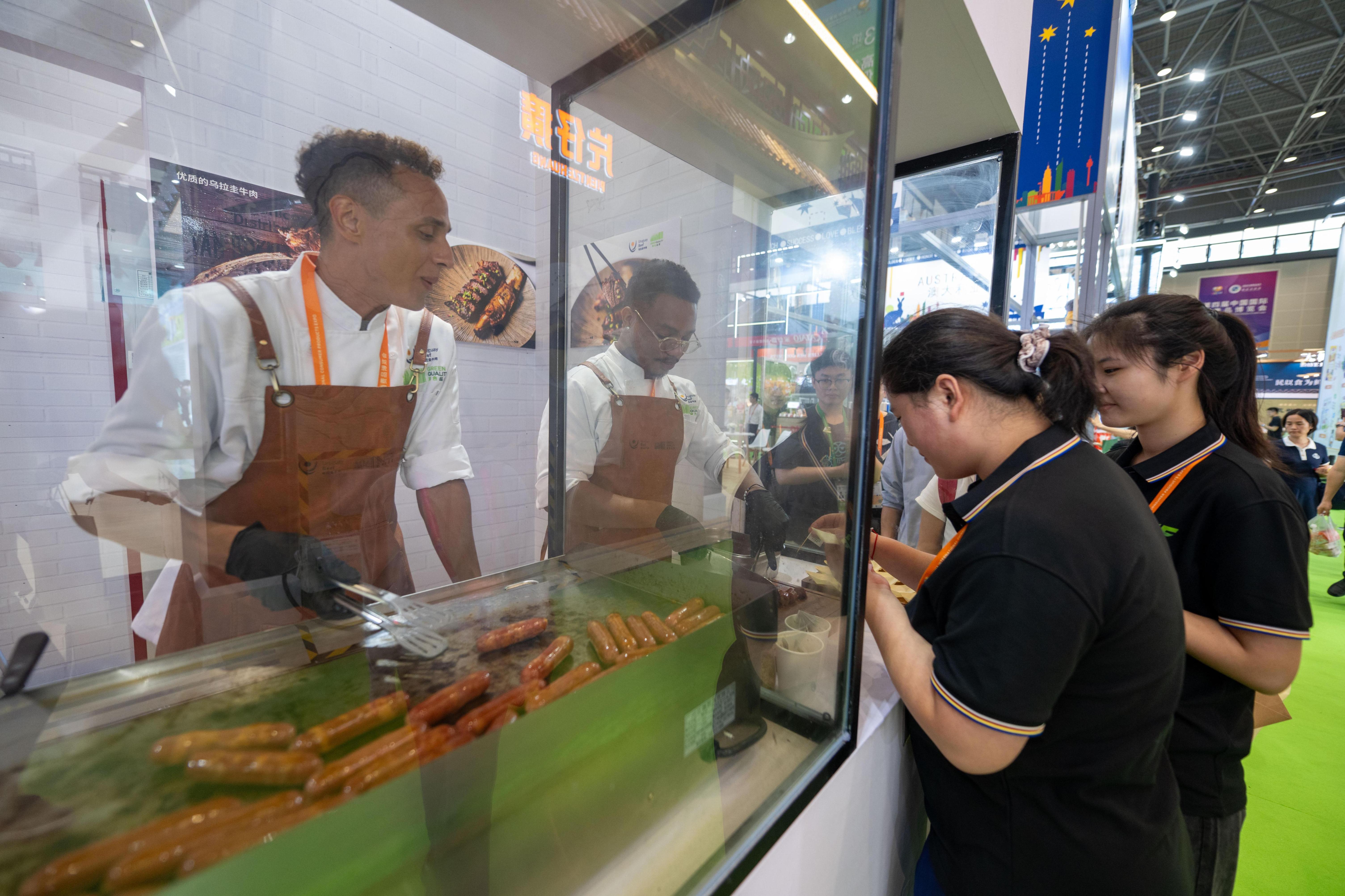 在高端食品保健品展區，參觀者正在排隊試吃來自烏拉圭的牛肉腸。人民網記者 翁奇羽攝