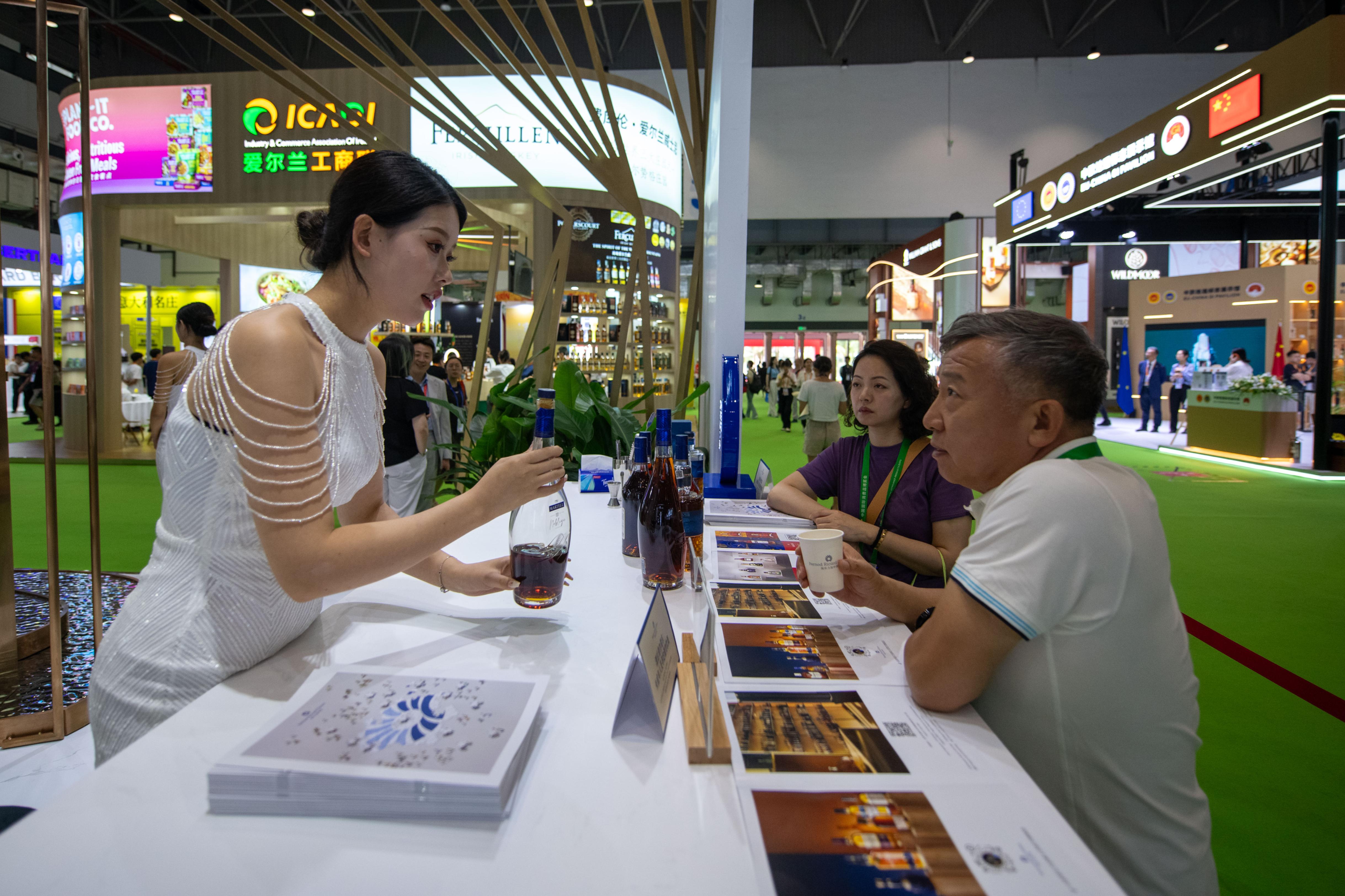 在高端食品保健品展區的保樂力加展台，參觀者正在品嘗洋酒。人民網記者 翁奇羽攝