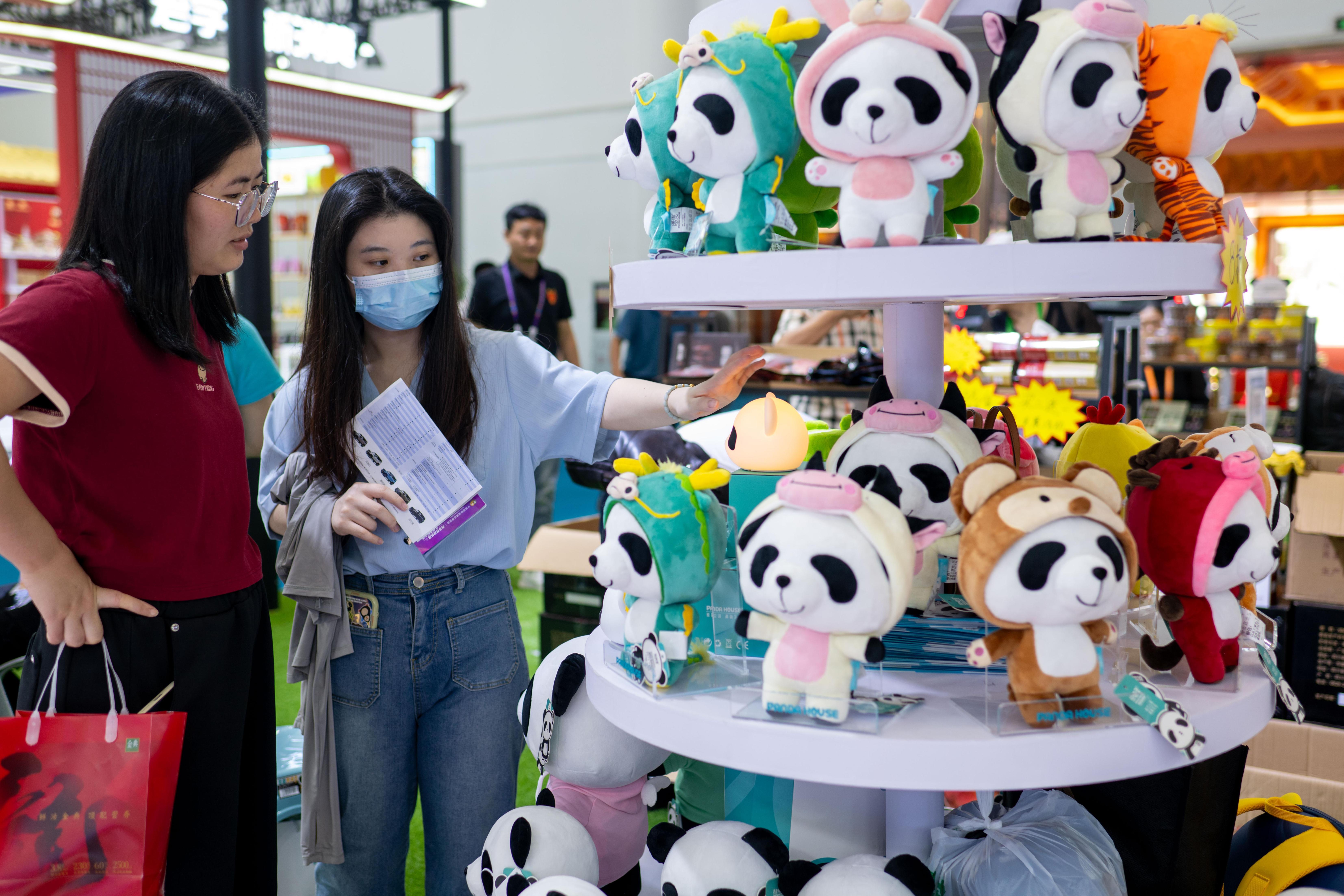 在國貨特色潮品展區，可愛的熊貓玩偶吸引不少參觀者的目光。人民網記者 翁奇羽攝