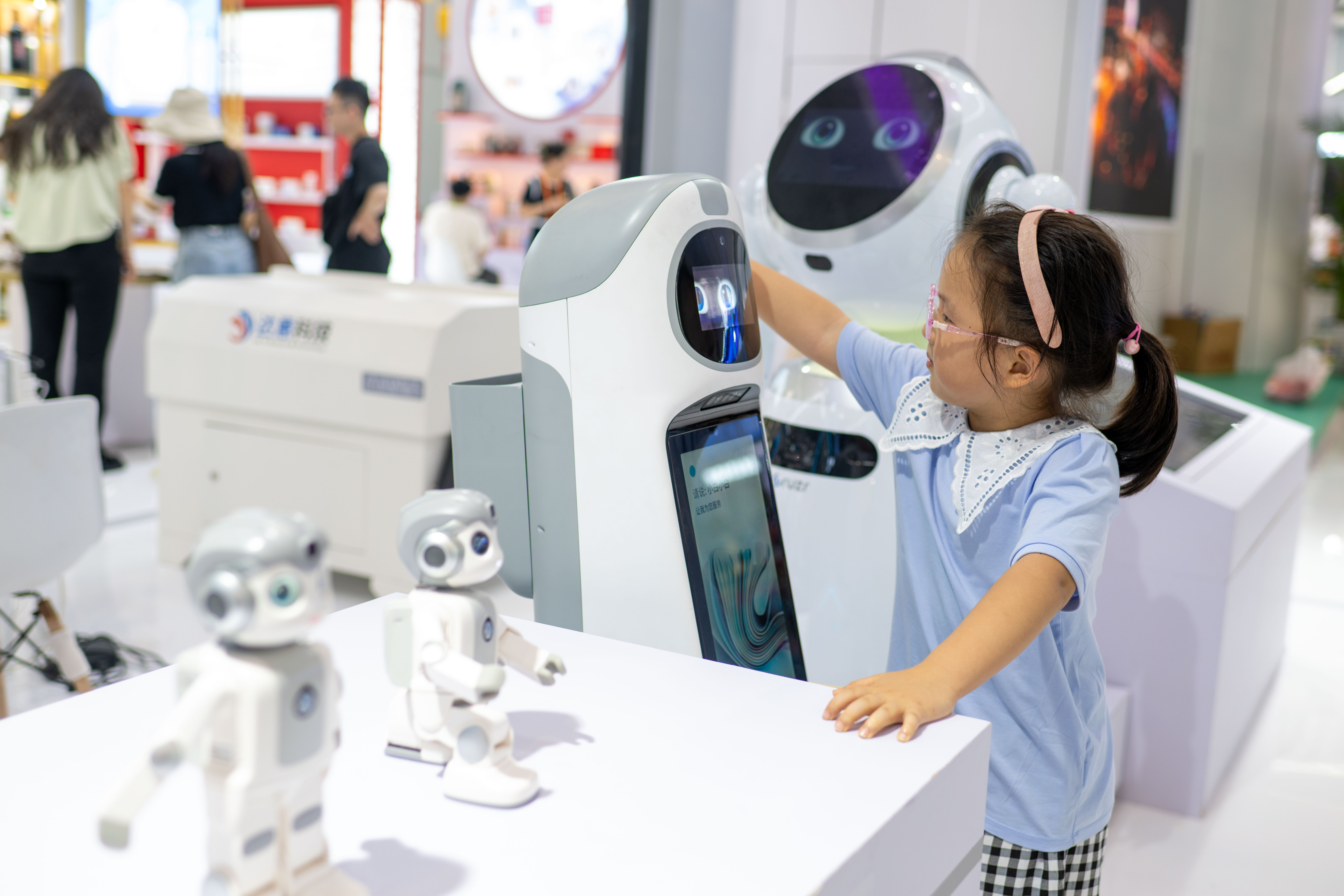在國貨特色潮品展區，小朋友與智能機器人玩耍。人民網記者 翁奇羽攝