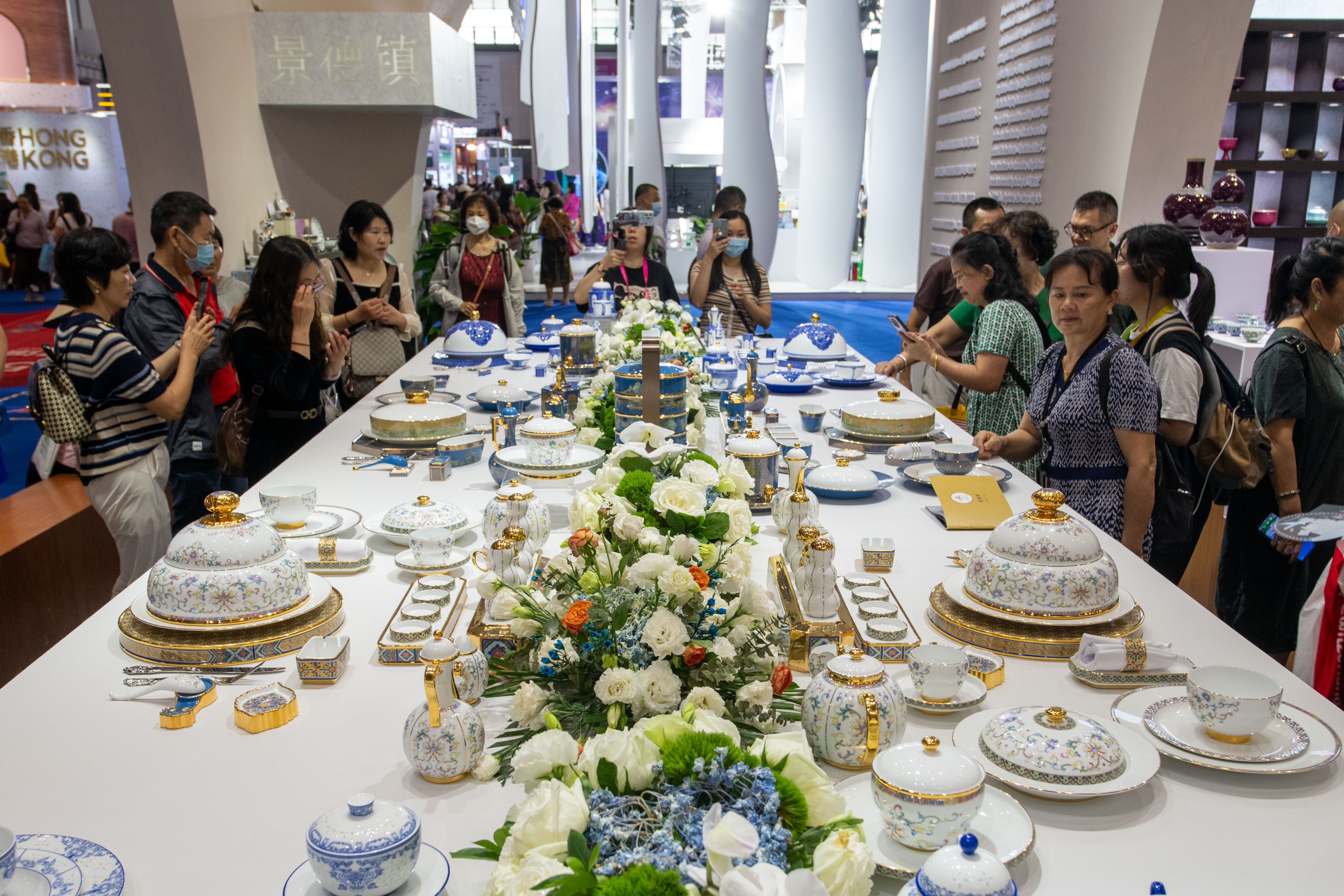 在全球特色消費展區的景德鎮展台，觀眾被精美的瓷質餐具吸引。人民網記者 翁奇羽攝