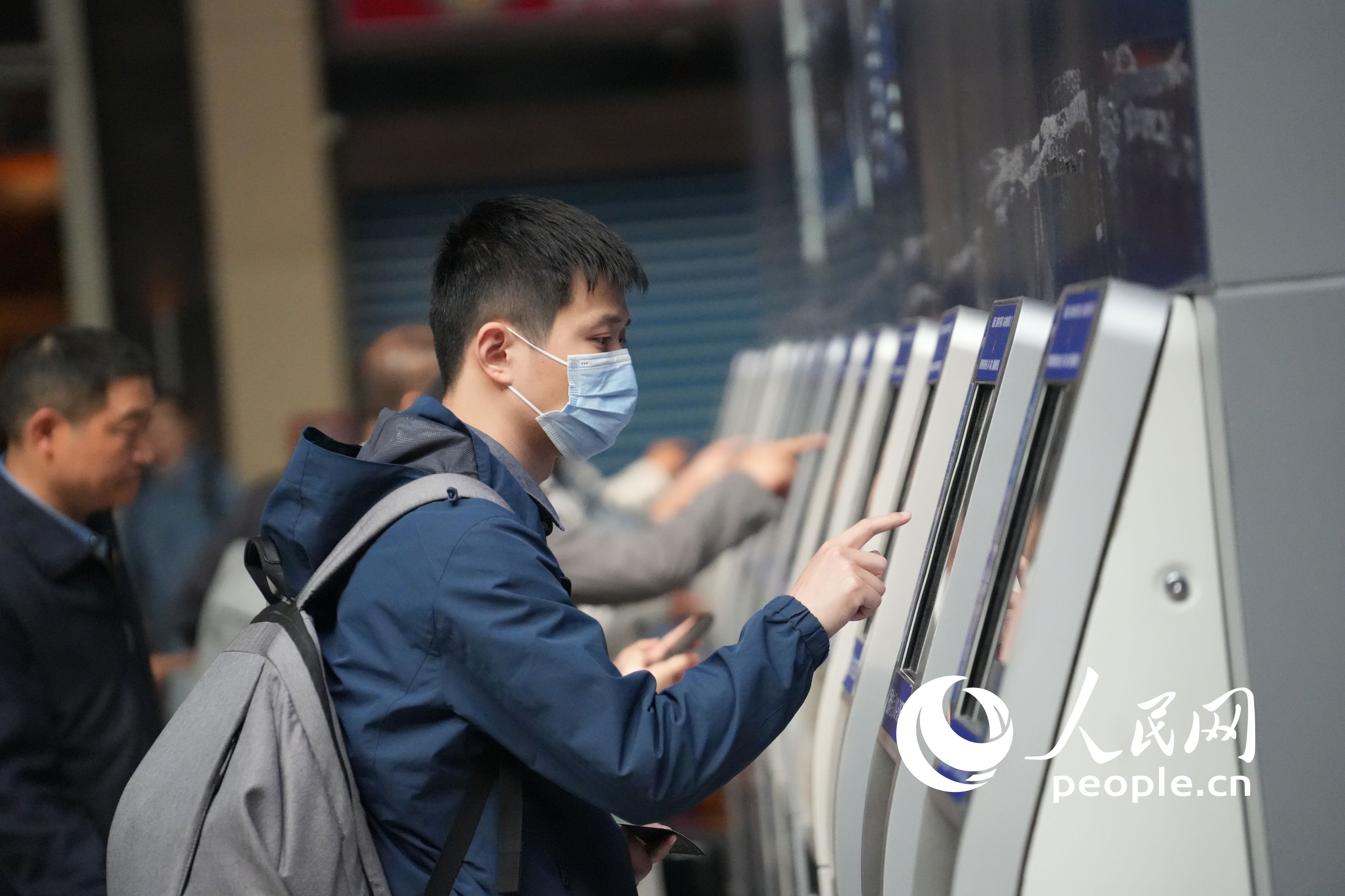 购取票机前操作的旅客。人民网记者 王天乐摄