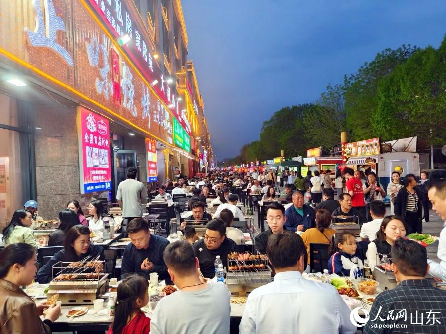  When the lights are on, Zhengwei Barbecue is full of customers inside and outside. Photographed by Song Cui, reporter of People's Daily Online