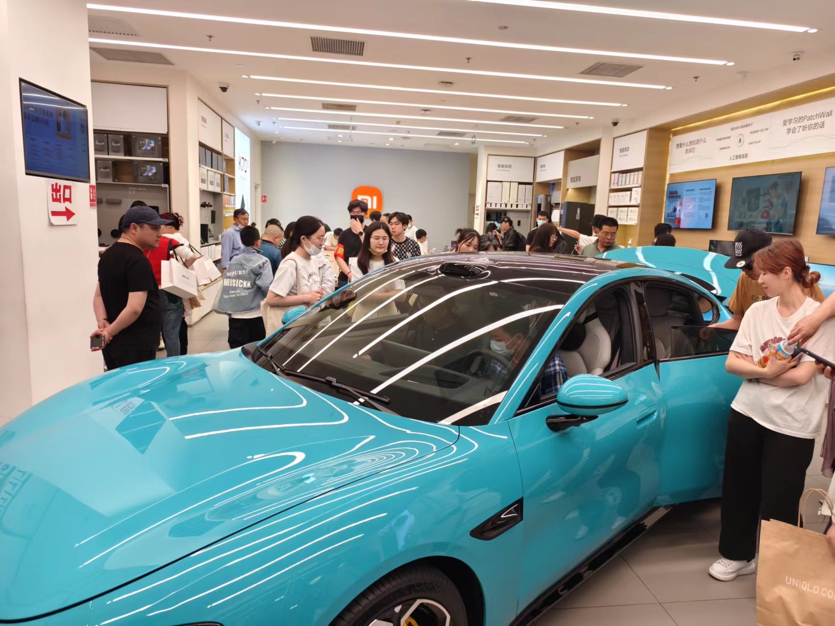 北京某商场新能源汽车展台，不少消费者前来咨询、体验。人民网记者 乔业琼摄