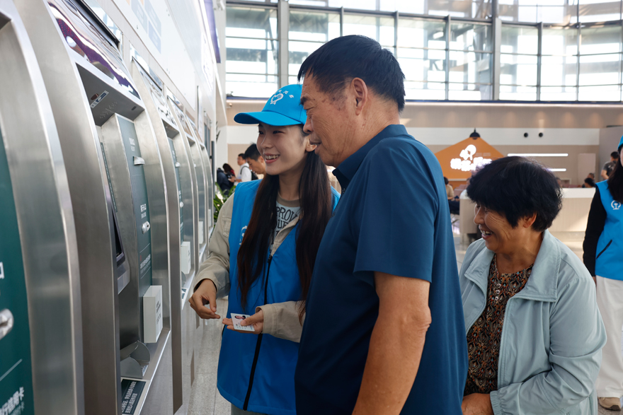 國慶假期，中國鐵路濟南局集團公司青島客運段開展志願服務，為旅客提供引導進展、輔助購票等服務。顏笑攝