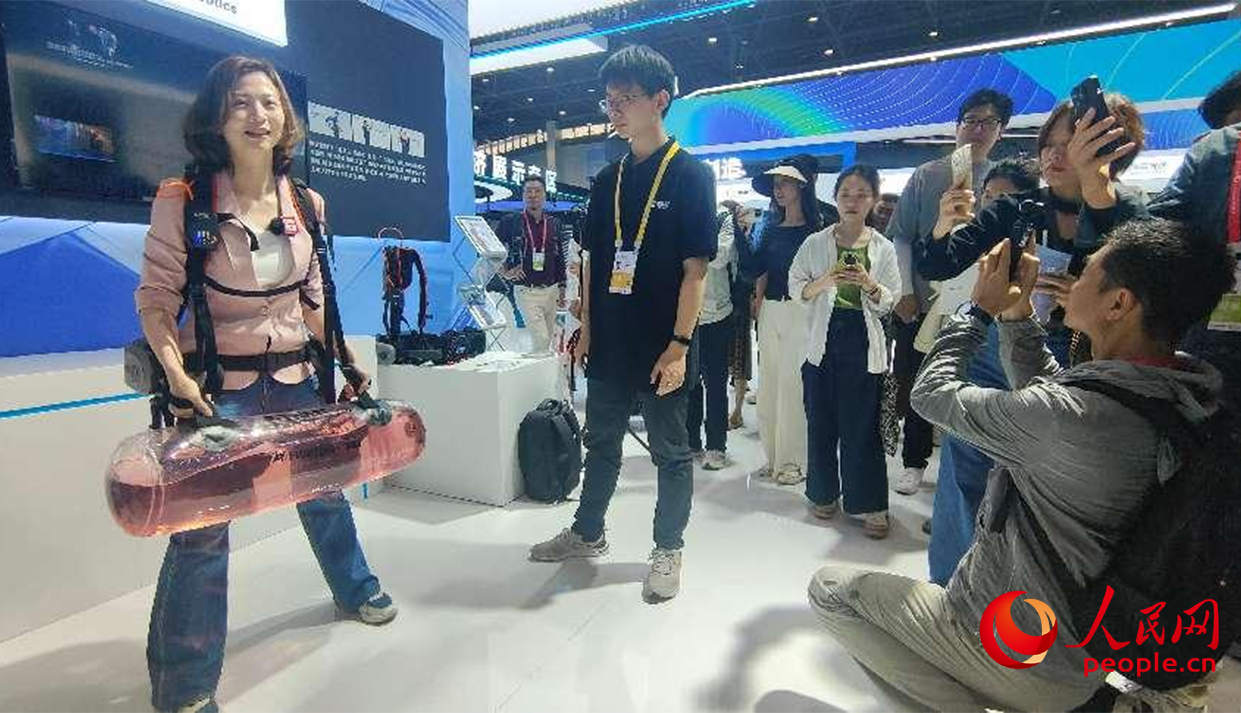 参观者穿戴设备，体验外骨骼机器人使用感受。人民网 欧阳易佳摄