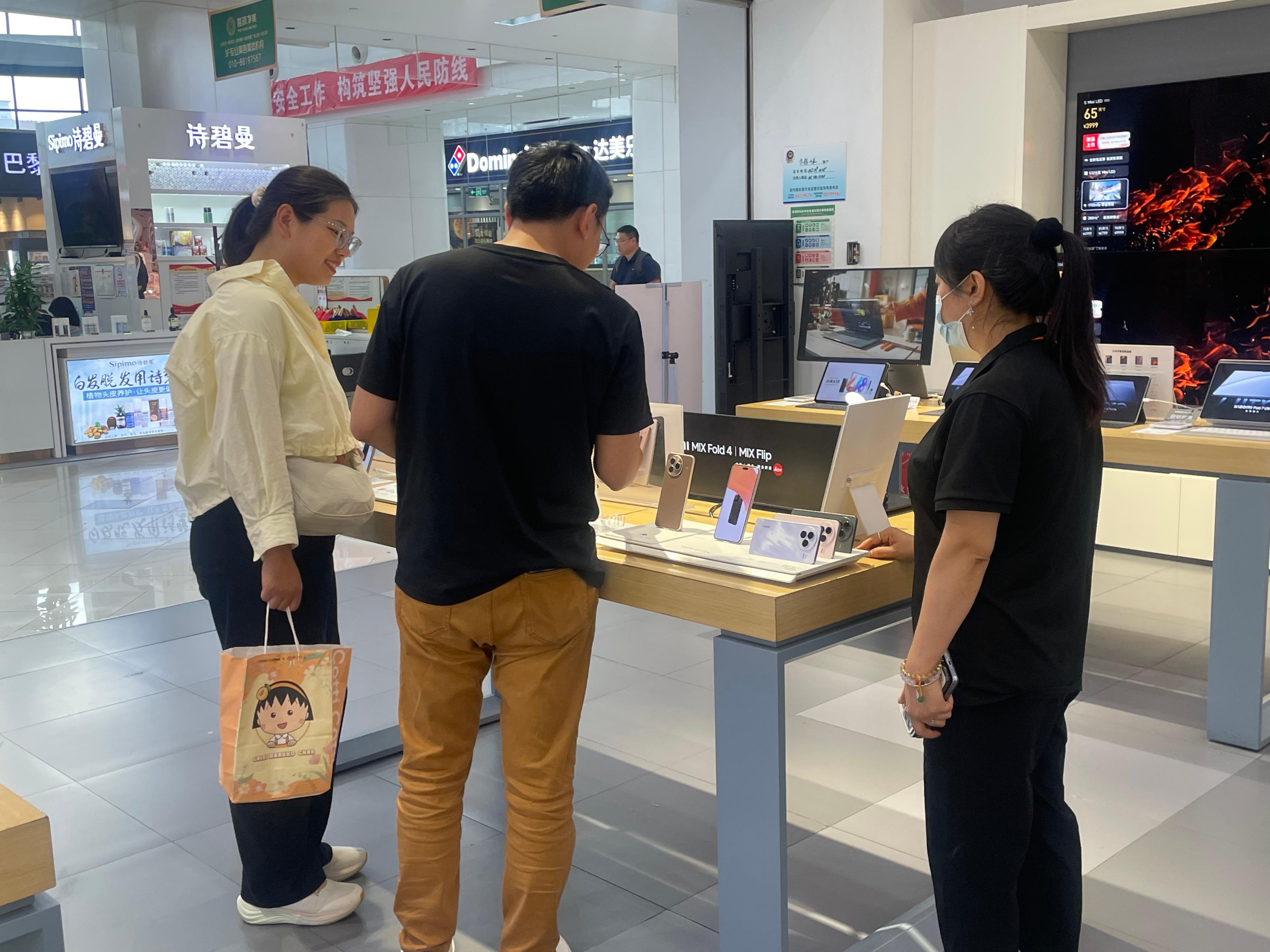 在北京市海淀区田村京粮广场内，市民们正在选购智能手机。 实习生 王琬迪摄