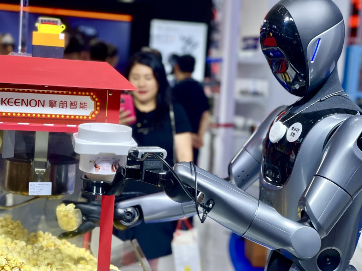 人形機器人 “爆米花西施” 正揮舞機械臂，為參展觀眾遞上剛出爐的美味爆米花。人民網記者 任妍攝
