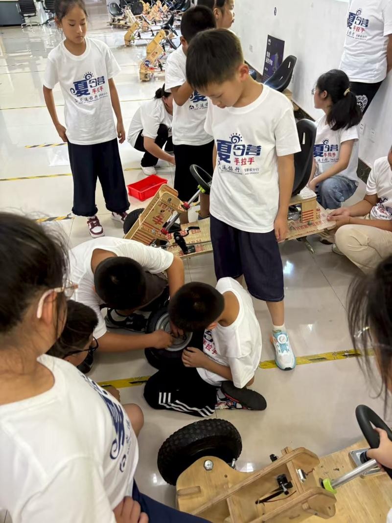 孩子们在蔚来先进制造工厂研究车辆模型。交通银行安徽省分行供图
