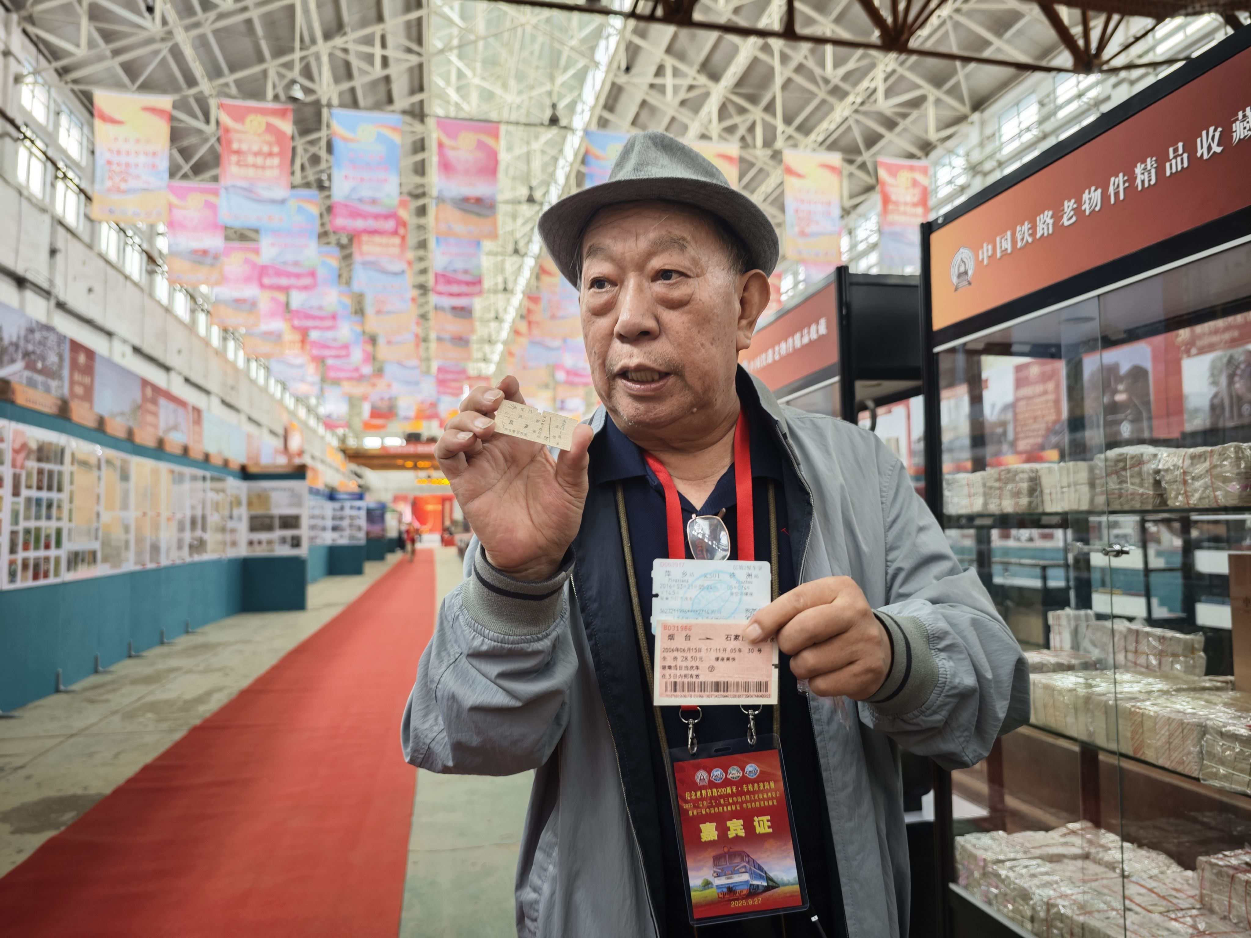 曾任中国铁道博物馆副馆长的金万智向参观者展示不同时期的中国火车票。人民网记者 王天乐摄