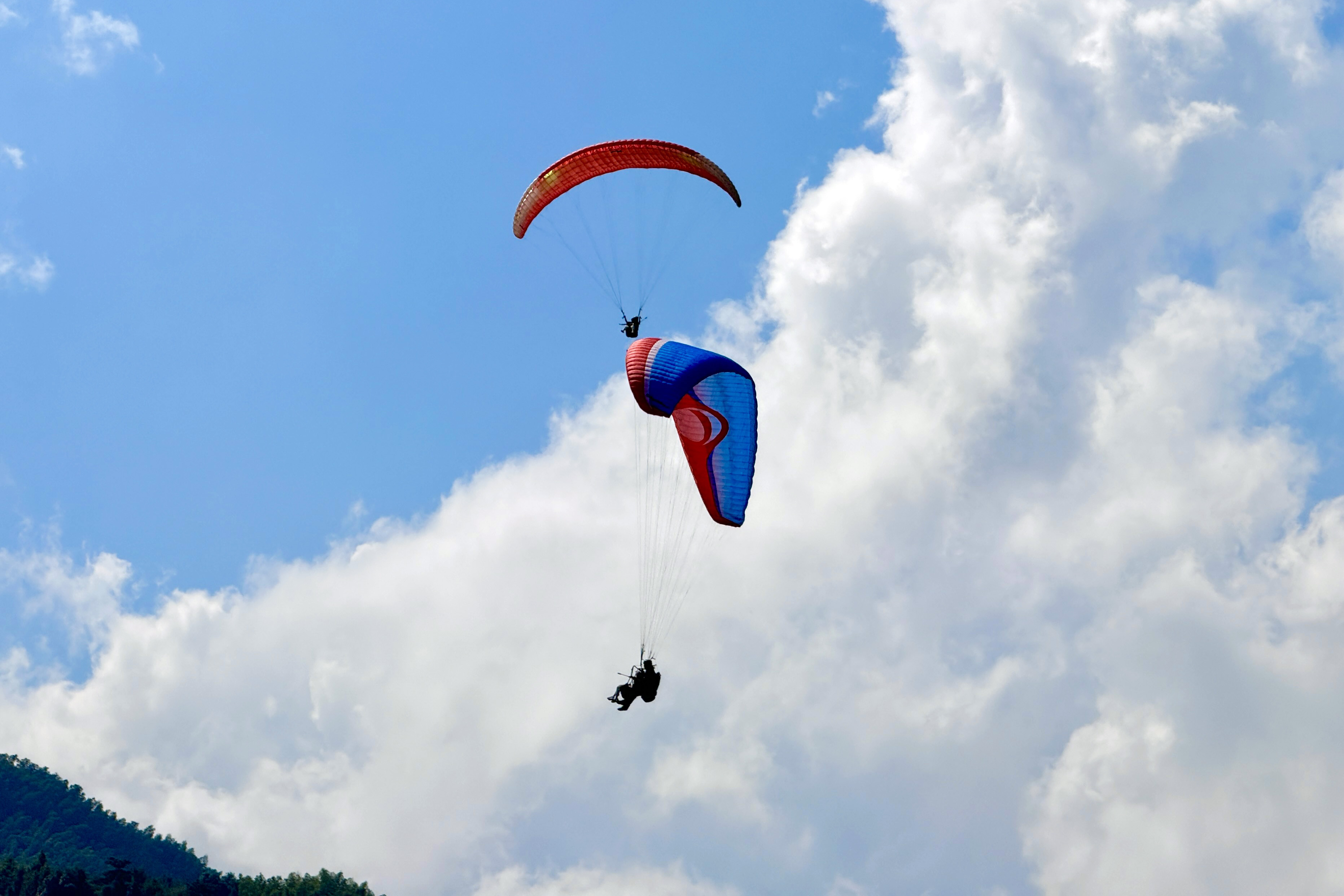 2025年10月4日，在江西省明月山滑翔伞飞行基地，游客正在体验滑翔伞项目。人民网记者 张隽摄