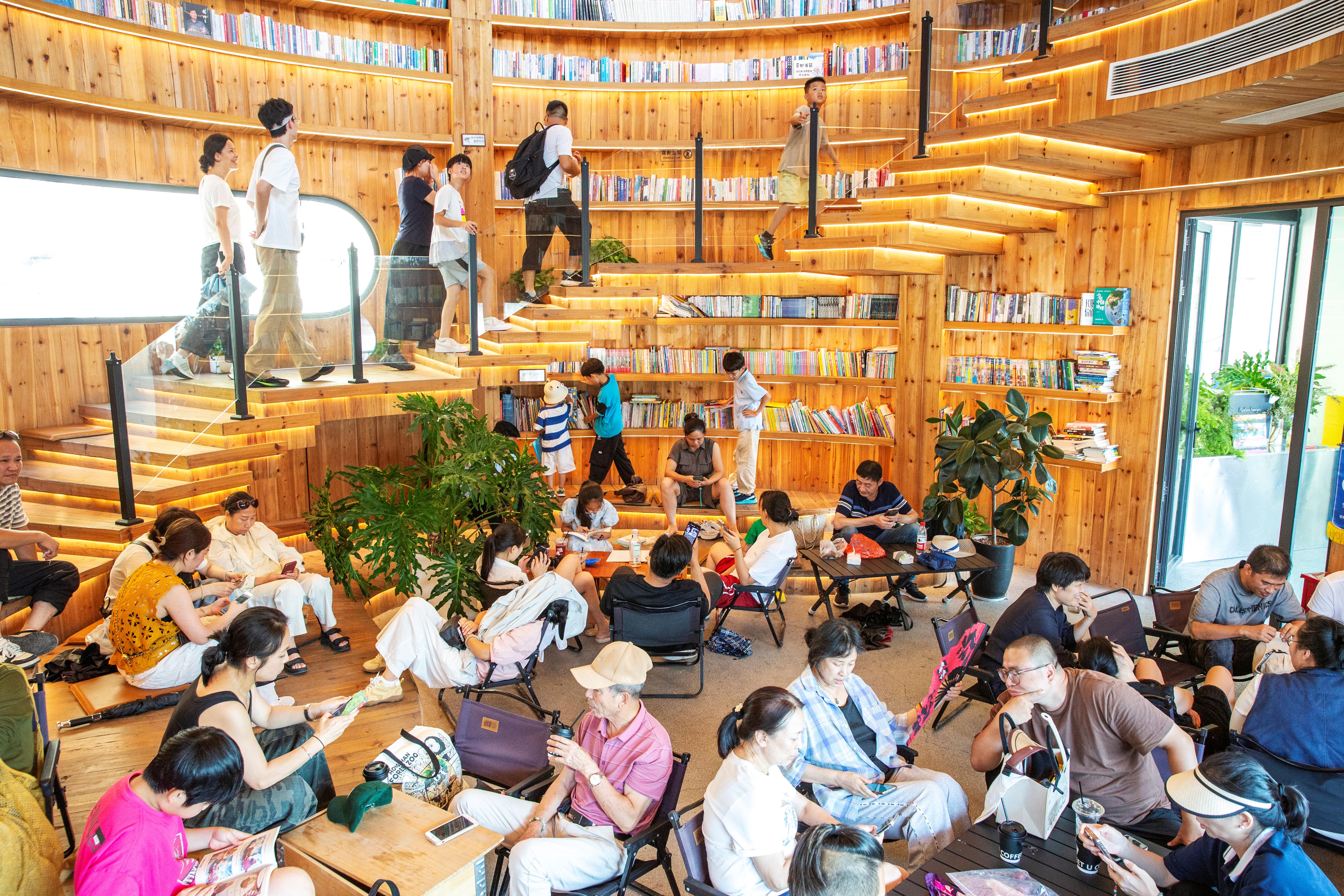 2025年10月7日,浙江省温州市苍南县金乡镇石砰码头,由老油库改造而成的咖啡馆内,游客们喝咖啡、品书香、赏海景。人民网记者 叶宾得摄