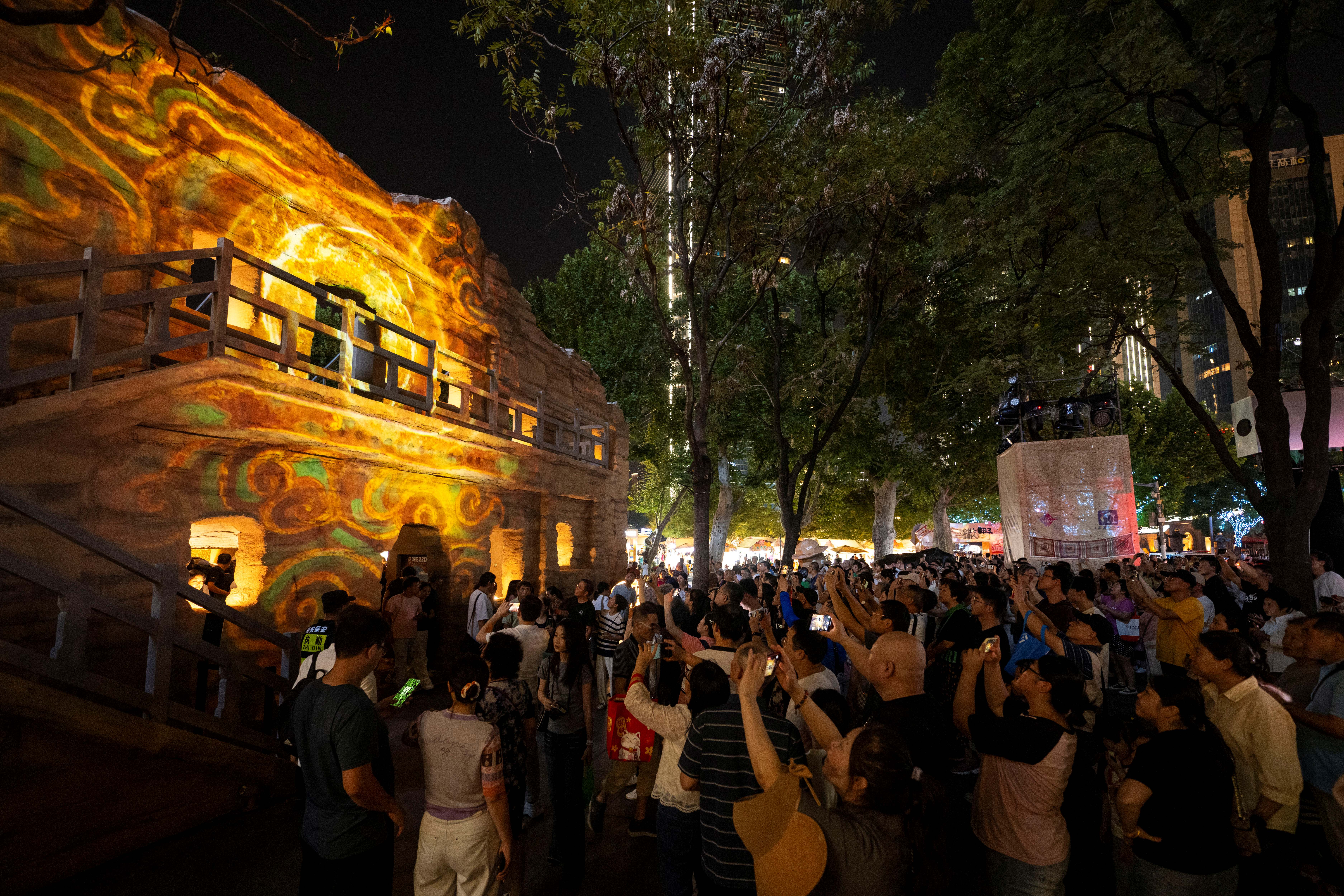 2025年10月2日,在上海静安公园,市民游客驻足观看《丝路光影》大型建筑光影秀。人民网记者 翁奇羽摄