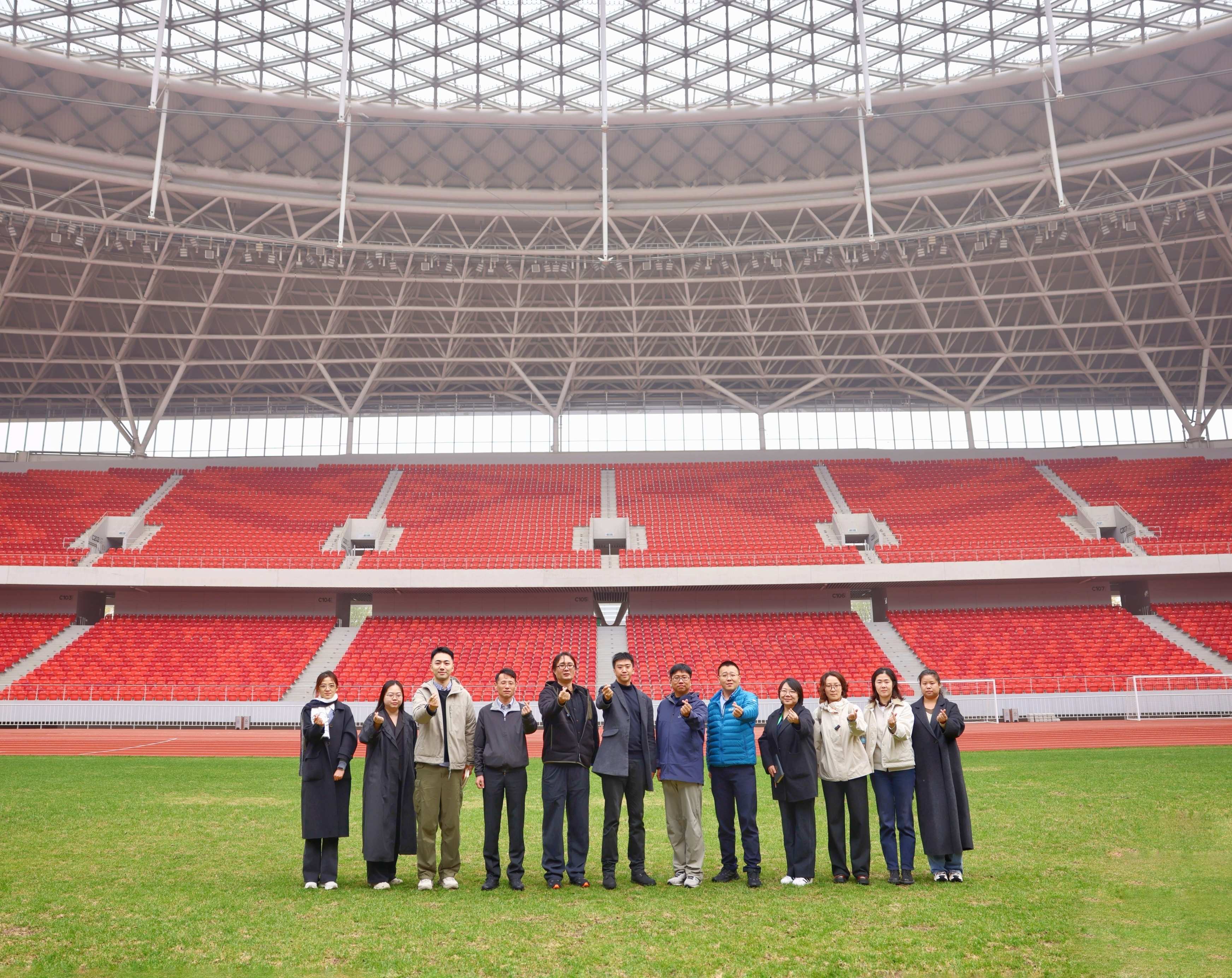 2025中国品牌论坛媒体采访调研团部分成员在雄安新区体育场合影。人民日报记者 蒋雨师摄