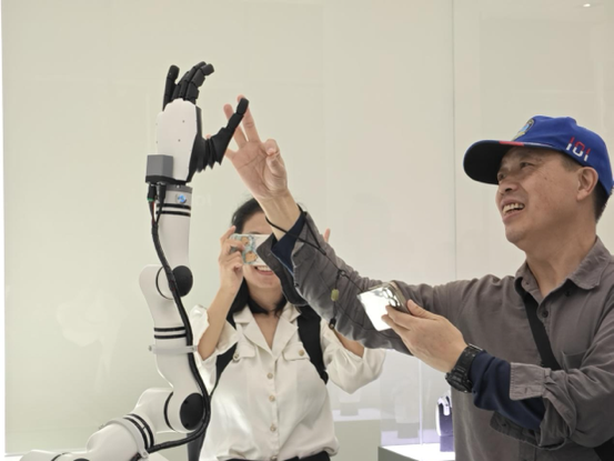 參觀者與具身智能機器人手臂進行互動。人民網記者 焦磊攝