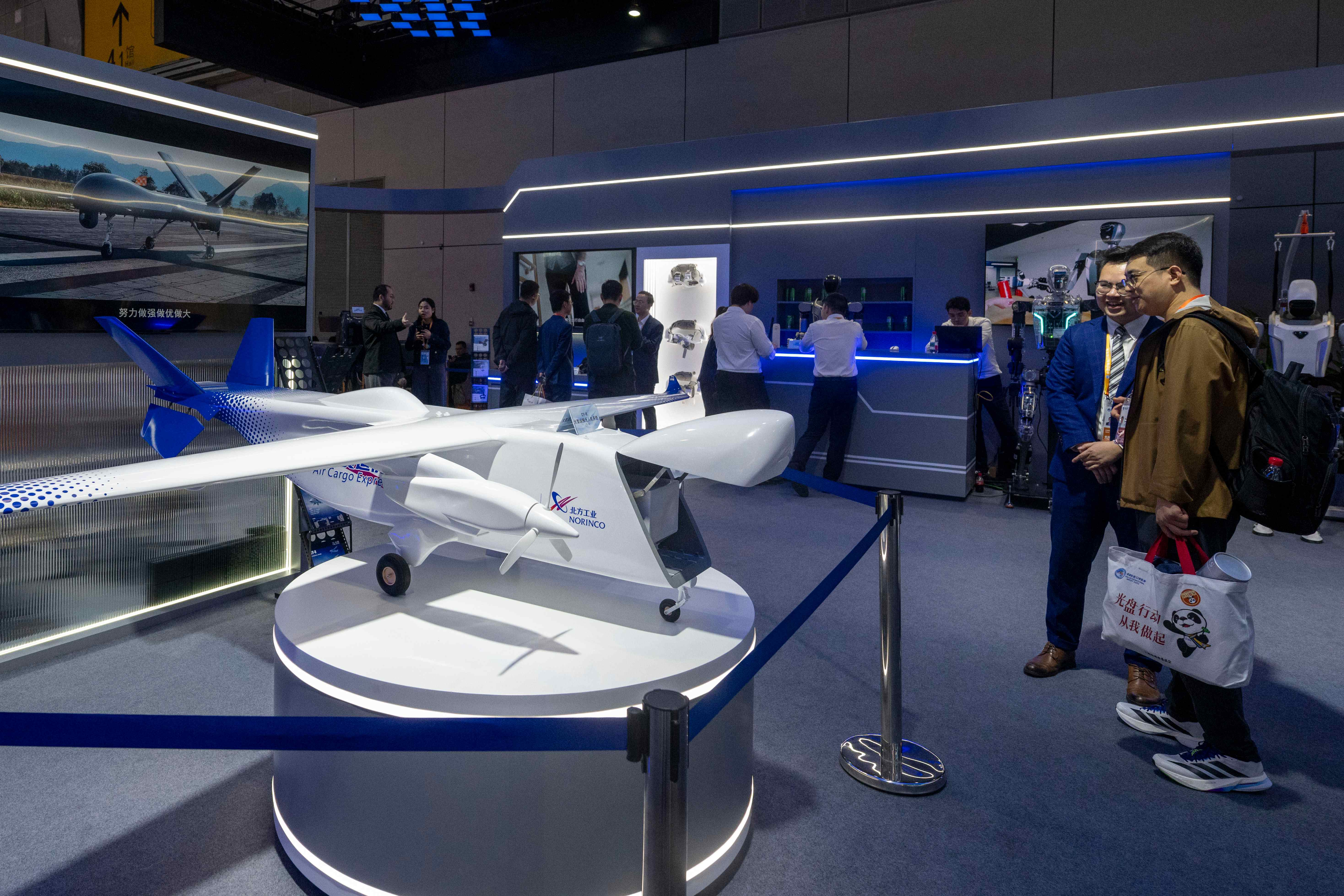 在第八屆進博會技術裝備展區的兵器工業海外展台,觀眾正在參觀了解大型運投無人機系統。人民網記者 翁奇羽攝