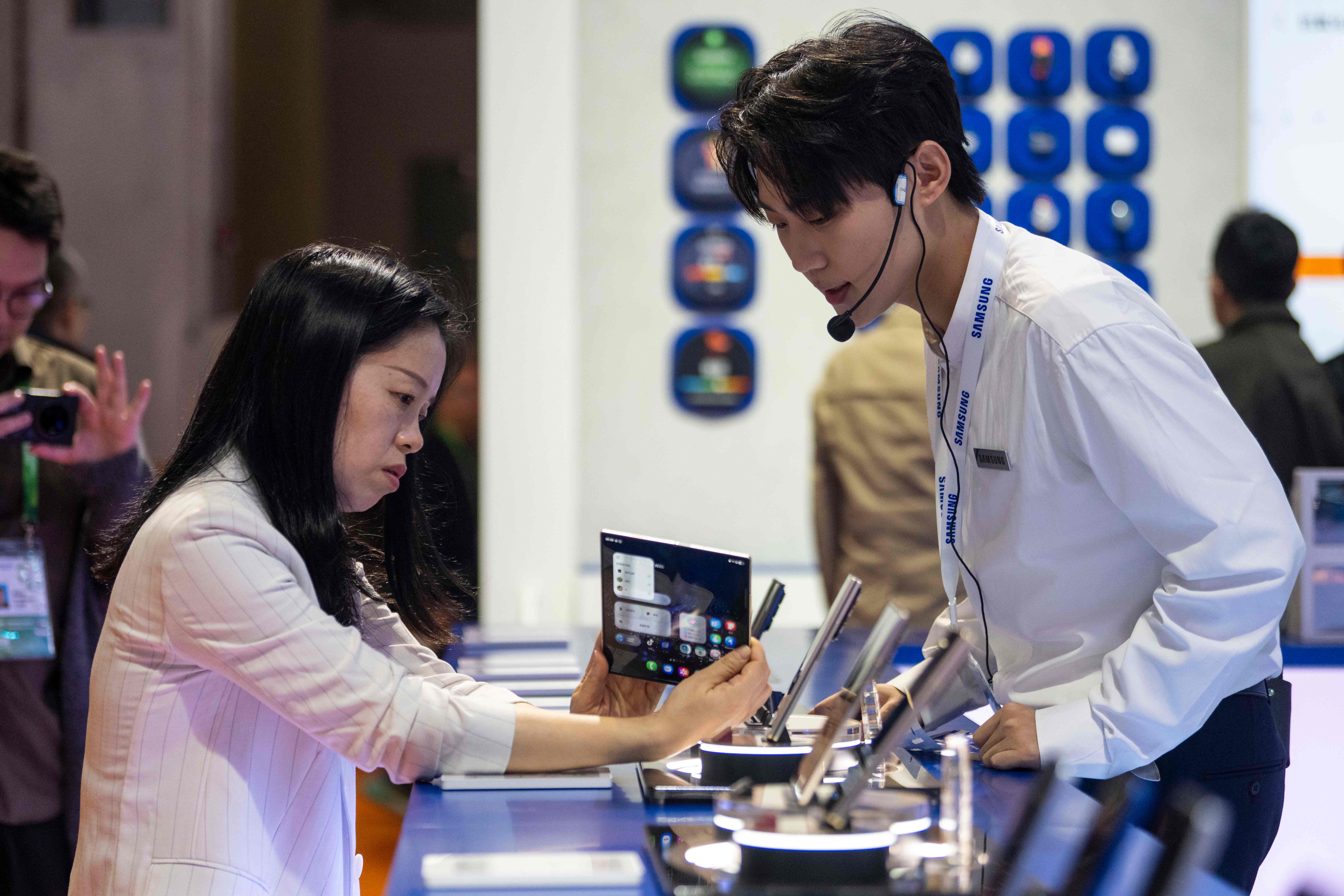 在第八屆進博會技術裝備展區的三星展台,參觀者正在體驗新款手機。人民網記者 翁奇羽攝