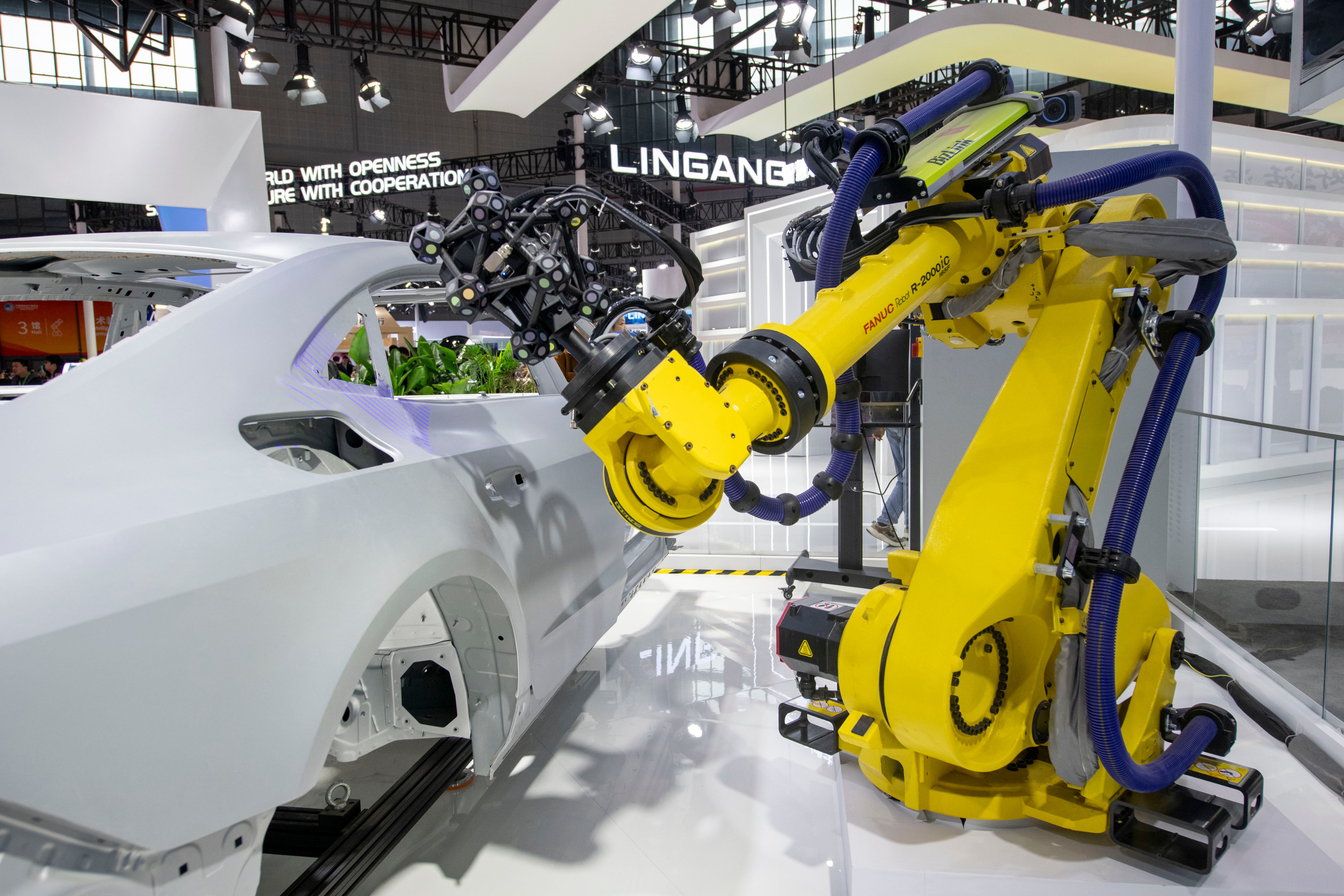 在第八屆進博會技術裝備展區的海克斯康展台,工業機器人正在演示自動化測量系統。人民網記者 翁奇羽攝