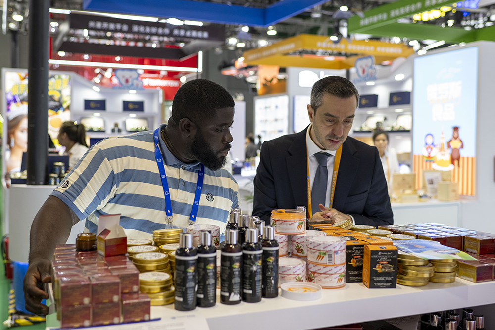 農食產品展區,外國參展商正在了解來自非洲的乳木果油護膚品。人民網記者 翁奇羽攝
