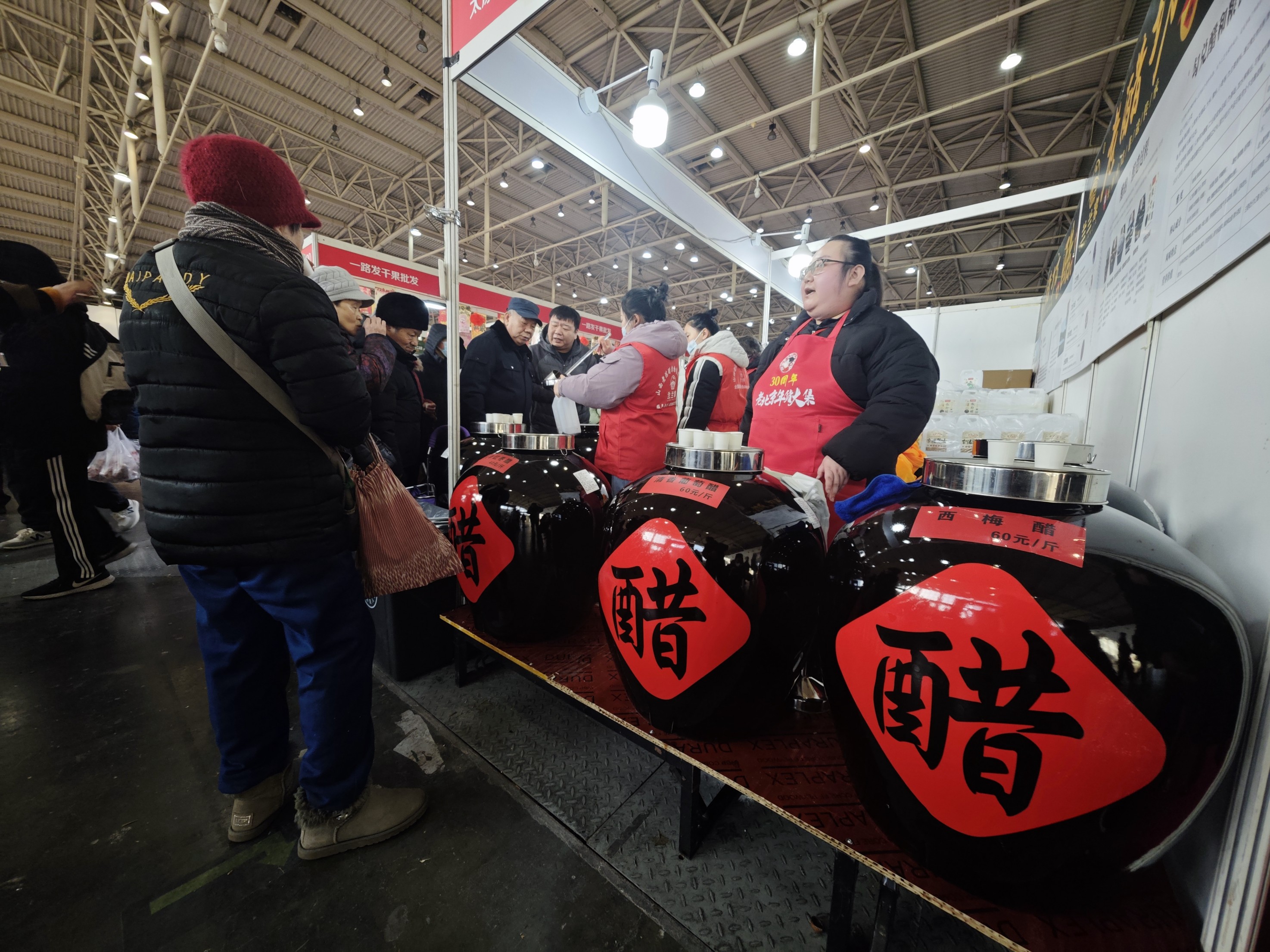 年货大集上，售卖陈醋的店主正在介绍产品。 人民网记者 王天乐摄