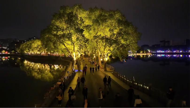游客在夜幕下的李公堤游玩。何玲摄