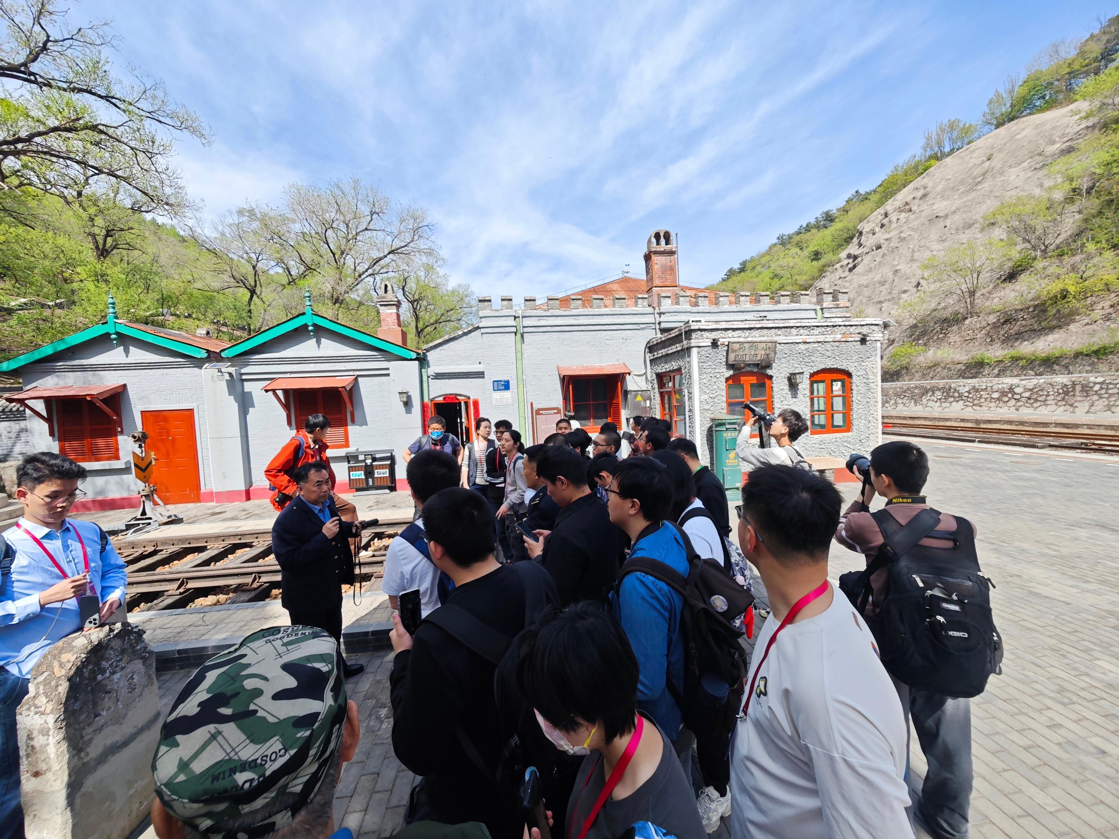 学生们在青龙桥车站与老站长杨存信进行交流。人民网记者 王天乐摄
